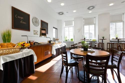 特里尔Kolping Hostel Trier im Warsberger Hof的餐厅内带桌椅的用餐室