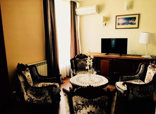 卡尔洛沃诗特利卡洛夫酒店的客厅配有桌椅和电视。