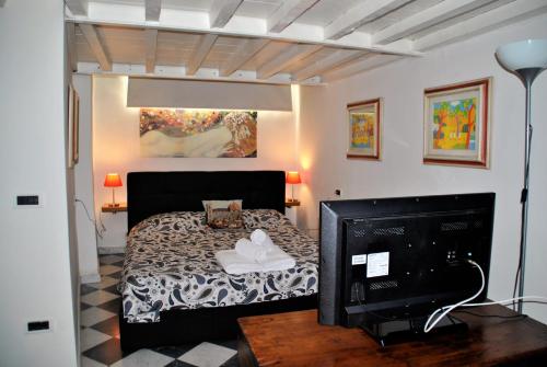 佛罗伦萨Suite Presto的一间卧室配有一张床和一台平面电视