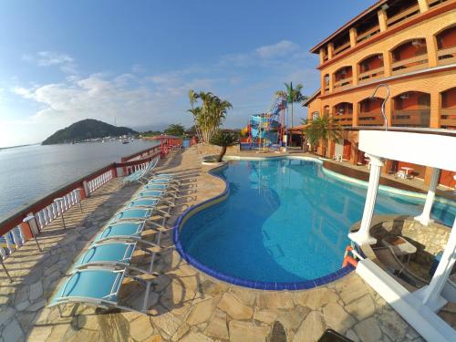 卡纳内亚Hotel Marazul的水边带躺椅的游泳池