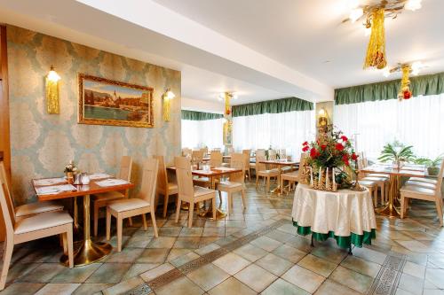 戈雷尼斯卡地区采尔克列Jagodic Garni Hotel的餐厅设有桌椅,墙上挂有绘画作品