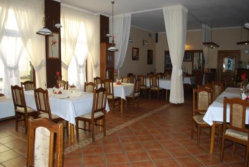 斯拉百斯安卡酒店 的一间设有白色桌椅和白色窗帘的餐厅