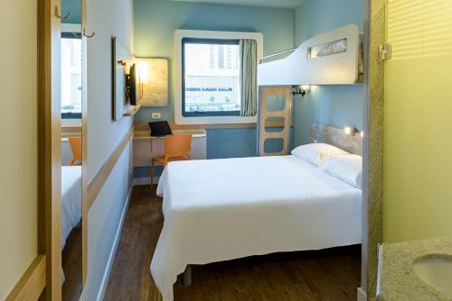 索罗卡巴ibis budget Sorocaba的卧室配有白色的床、窗户和水槽