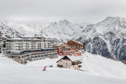 索尔登Hotel Enzian Hochsölden Superior的一个人在雪覆盖的山里滑雪