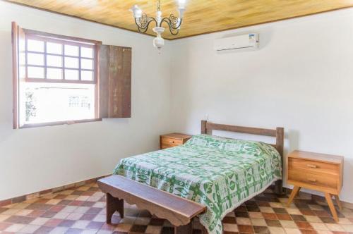 蒂拉登特斯Pouso copo de leite的一间卧室配有一张床、一张桌子和一个窗户。