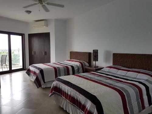 通苏帕Makana Suite 6-11的一间卧室配有两张床和条纹毯子