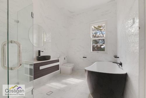 肯图巴峰会之家度假屋的带浴缸、卫生间和窗户的浴室