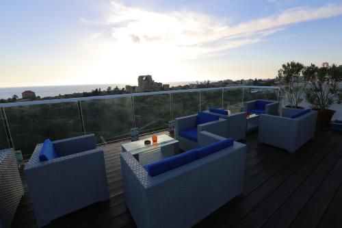 朱拜勒艾礼富精品酒店的阳台的甲板上配有蓝色的椅子和一张桌子