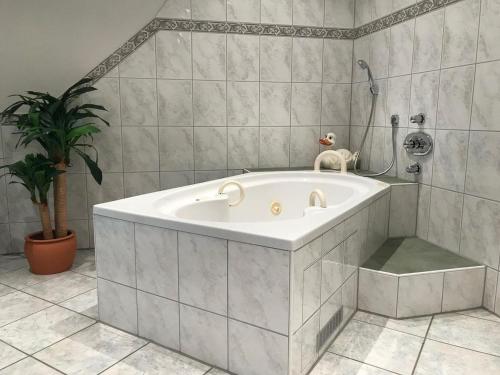 欣特察尔滕Hotel Zartenbach B&B的带浴缸的浴室,种植了盆栽植物