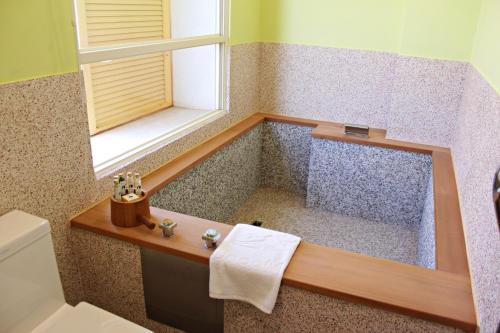 后里星月文旅溫泉民宿的一间带窗户和水槽的浴缸的浴室