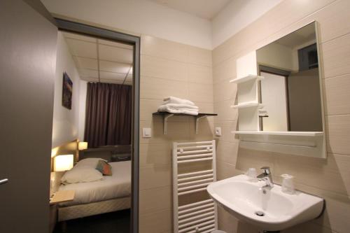图卢兹帕潘沃尔德努伊酒店的一间带水槽和镜子的浴室以及一张床