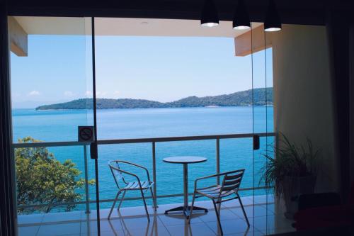 安格拉杜斯雷斯绿色海洋公寓酒店的阳台配有桌椅,享有海景。
