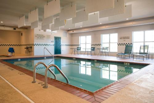 埃芬汉埃芬汉乡村套房酒店的一个带桌椅的房间的大型游泳池