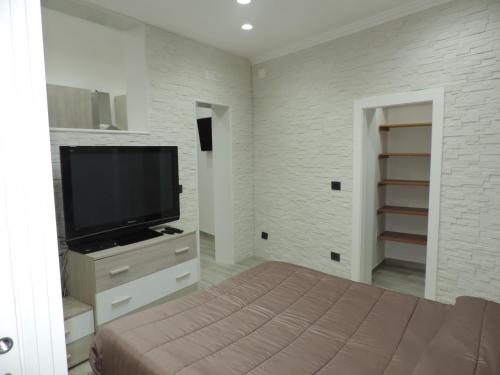 莱波拉诺La Casetta的一间卧室设有平面电视和一张床。