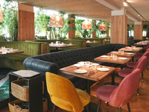 塞维利亚英伦酒店的餐厅设有木桌、椅子和沙发。