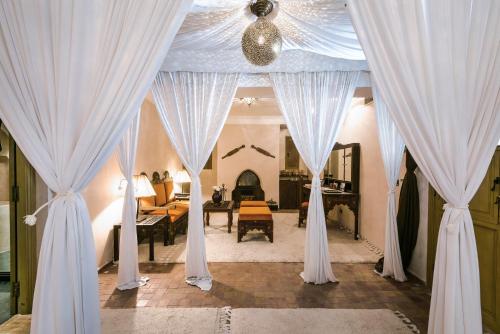 马拉喀什Almaha Marrakech Restaurant & SPA的一间设有白色窗帘的房间和一间客厅