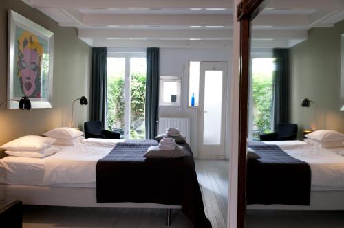 阿姆斯特丹西紫罗兰家庭旅馆的一间卧室配有两张床和两把椅子