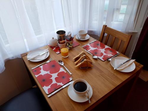 韦茅斯Fosters Guest House的一张木桌,上面有食物和饮料