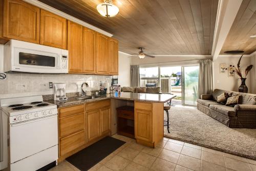 科帕利斯比奇Beachwood Condos & Resort的一间带白色炉灶的厨房 沙发旁的顶部烤箱