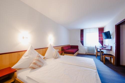 阿尔腾斯塔特祖姆鲁斯勒酒店的酒店客房配有白色的床和红色沙发