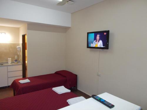 圣米格尔·德·图库玛Apart Office的客房设有两张床和一台墙上的电视。