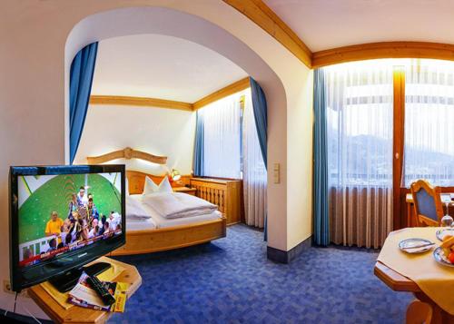 贝希特斯加登四季酒店的配有一张床和一台平面电视的酒店客房