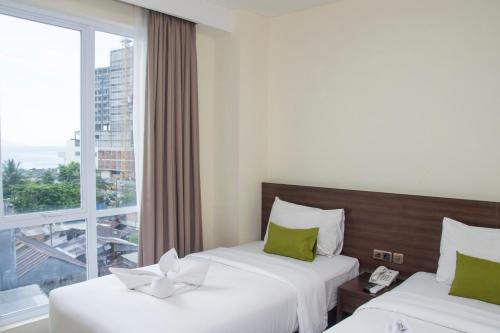 美娜多绿色伊甸园酒店的配有窗户的酒店客房内的两张床