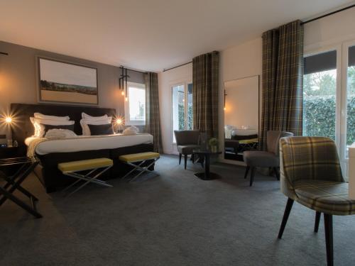 厄尔河畔帕西Hôtel-Restaurant Bel Ami的卧室配有一张床、一张桌子和椅子