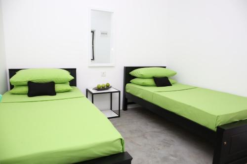 韦利格默THE CLASSIC-Hostel-apartment-Standard Room的配有绿床单和枕头的客房内的两张床