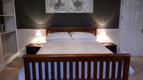 麦斯堡Stonehouse Apartment的一间卧室配有一张带2个床头柜的大床