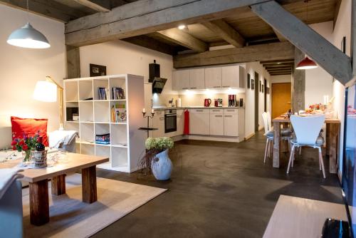 奎德林堡Ferienappartements im Speicherwerk的厨房以及带白色橱柜和桌子的客厅。