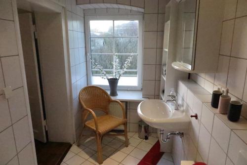 PlathNussbaumhof mit Koppel的一间带水槽、椅子和窗户的浴室
