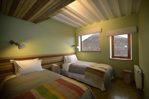 纳塔列斯港Hotel Vendaval的一间卧室设有两张床和两个窗户。