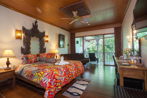 芭东海滩Tropica Bungalow Beach Hotel的一间卧室设有一张床和一间客厅。