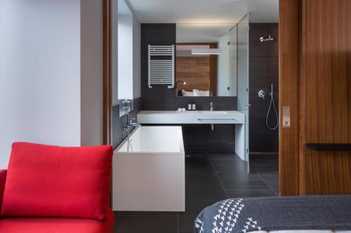 雷克雅未克ION City Hotel, Reykjavik, a Member of Design Hotels的浴室设有红色椅子,毗邻水槽