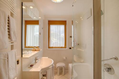 阿拉巴B&B Garni Serena的白色的浴室设有水槽和淋浴。
