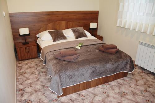 莫龙格伊雷娜酒店的一间卧室配有一张大床和木制床头板