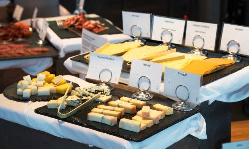 奥斯陆Thon Partner Hotel Ullevaal Stadion的餐桌上摆放着奶酪和其他开胃菜