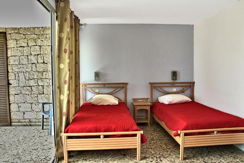 阿雅克修Hotel la Parata的一间卧室配有两张带红色床单和镜子的床