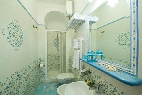 普莱伊亚诺贝壳酒店的蓝色和白色的浴室设有水槽和卫生间