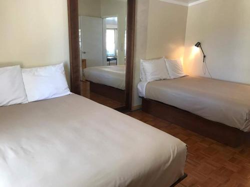 ShoshoneShoshone RV Park的酒店客房,设有两张床和镜子