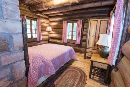 PinevillePine Mountain State Resort Park的小木屋内一间卧室,配有一张床