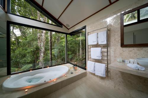 Crystal Creek水晶小溪雨林山林小屋的一间带大浴缸和大窗户的浴室