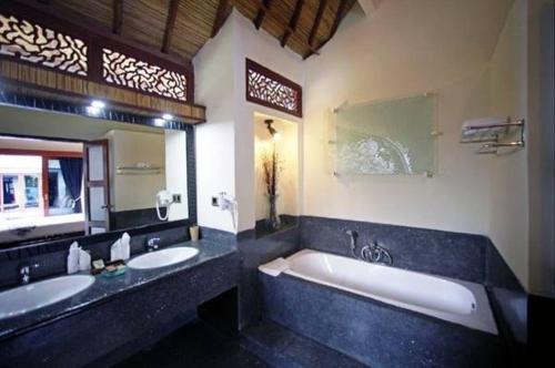 吉利特拉旺安卢斯阿尔玛套房度假村&Spa的一间带两个盥洗盆和大浴缸的浴室