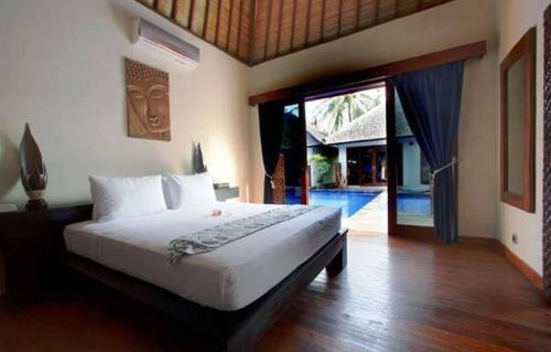 吉利特拉旺安卢斯阿尔玛套房度假村&Spa的一间卧室设有一张床和一个滑动玻璃门