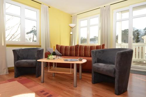 奥斯赛拜-塞林Villa Seerose - Appartement 04的客厅配有沙发、两把椅子和一张桌子