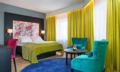 阿伦达尔吞阿伦达尔酒店 的酒店客房带床和五颜六色的椅子