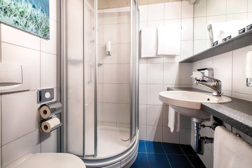 苏黎世苏黎世雷奥纳多精品酒店的带淋浴、卫生间和盥洗盆的浴室