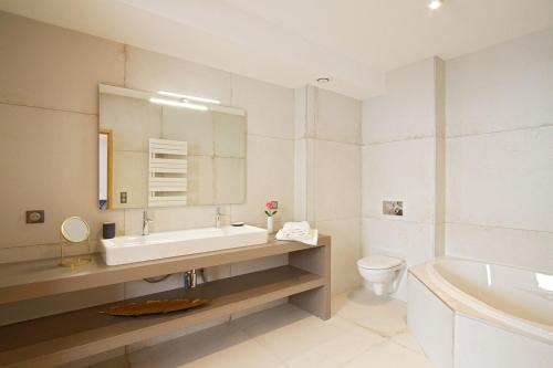 拉普德兹Odalys Chalet Nuance de gris的浴室配有盥洗盆、卫生间和浴缸。