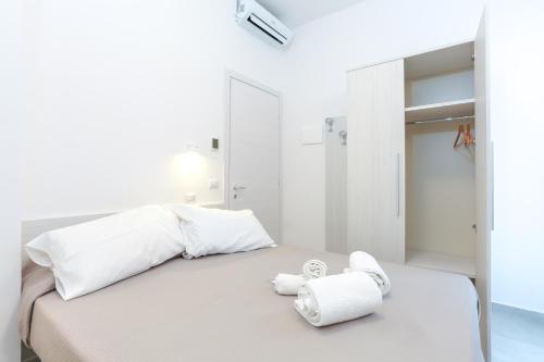里米尼Hotel Tourist Meuble的白色卧室,配有带毛巾的床